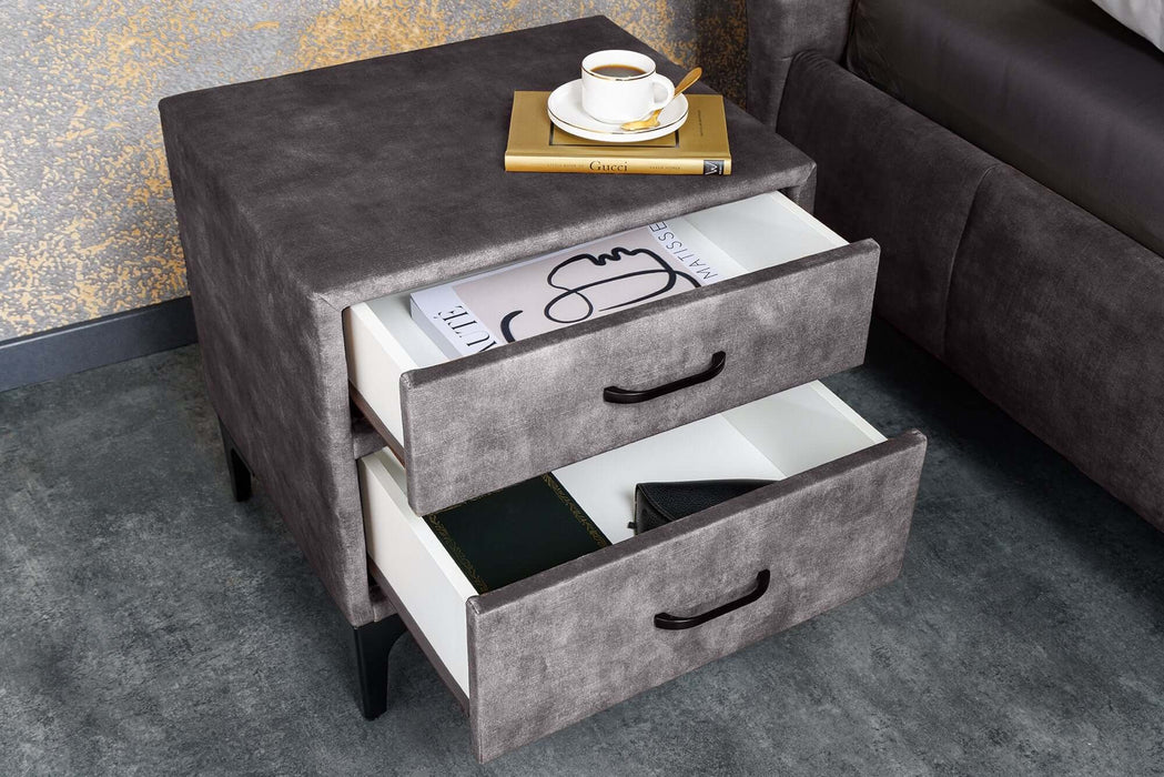 Eleganter dunkelgrauer Nachttisch aus Samt mit zwei Schubladen und einer Tasse Kaffee darauf.